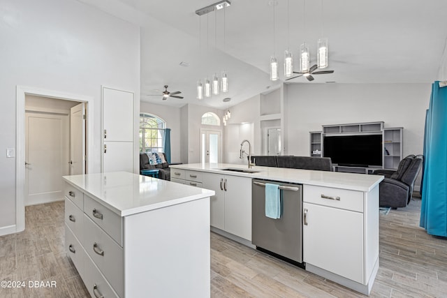 kitchen with ceiling fan, sink, white cabinets, light hardwood / wood-style floors, and an island with sink