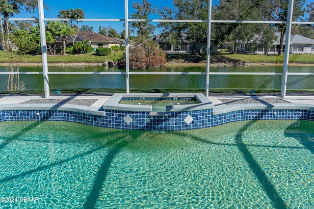 view of pool featuring an in ground hot tub and a water view