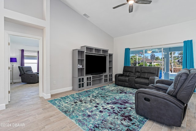 living room featuring light hardwood / wood-style floors, high vaulted ceiling, a wealth of natural light, and ceiling fan