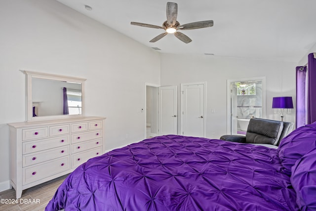 bedroom with ceiling fan, light hardwood / wood-style flooring, ensuite bathroom, and vaulted ceiling