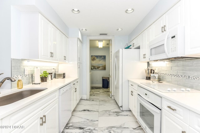 kitchen featuring white cabinetry, white appliances, sink, and backsplash