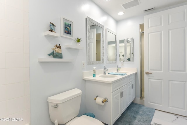 bathroom with toilet, vanity, and an enclosed shower