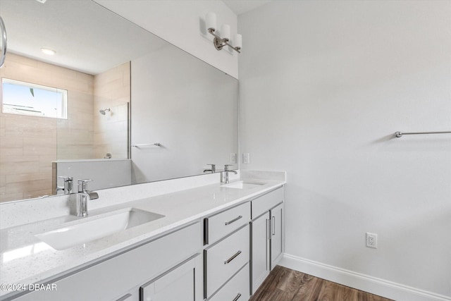 bathroom with vanity, hardwood / wood-style floors, and tiled shower