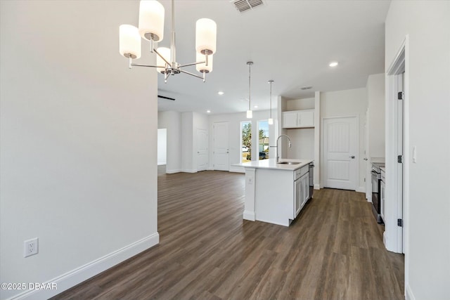 kitchen with an island with sink, sink, white cabinets, dark hardwood / wood-style flooring, and hanging light fixtures