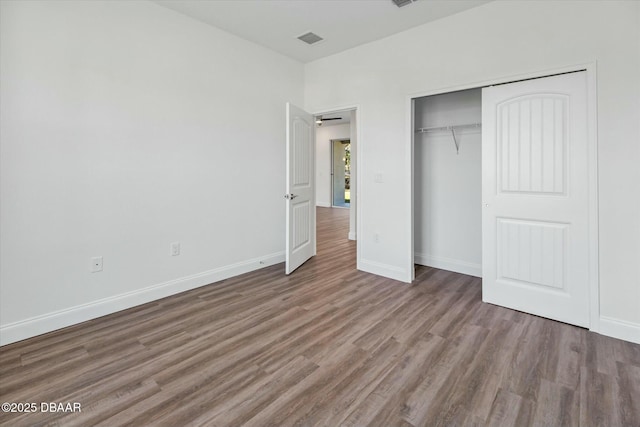 unfurnished bedroom featuring dark wood-type flooring and a closet