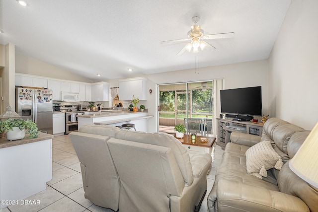 tiled living room featuring ceiling fan and vaulted ceiling