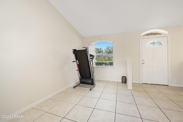 entrance foyer with lofted ceiling and light tile patterned floors