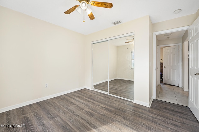 unfurnished bedroom featuring dark hardwood / wood-style flooring, a closet, and ceiling fan