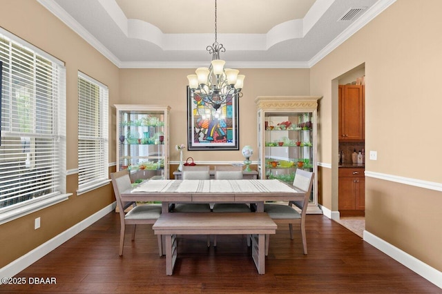612 Aldenham Ln, Ormond Beach, FL 32174 - dining space with a raised ceiling, a chandelier, dark wood finished floors, baseboards, and ornamental molding