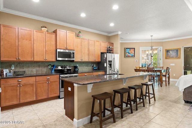 612 Aldenham Ln, Ormond Beach, FL 32174 - kitchen with stainless steel appliances, a kitchen island with sink, decorative backsplash, light tile patterned flooring, and recessed lighting