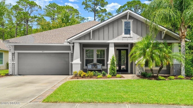 612 Aldenham Ln, Ormond Beach, FL 32174 - view of front facade featuring an attached garage, board and batten siding, a front lawn, concrete driveway, and roof with shingles
