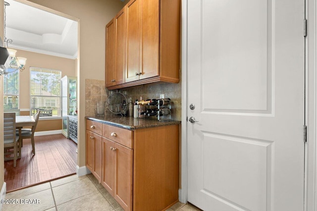 612 Aldenham Ln, Ormond Beach, FL 32174 - kitchen with crown molding, tasteful backsplash, a chandelier, baseboards, and light tile patterned floors