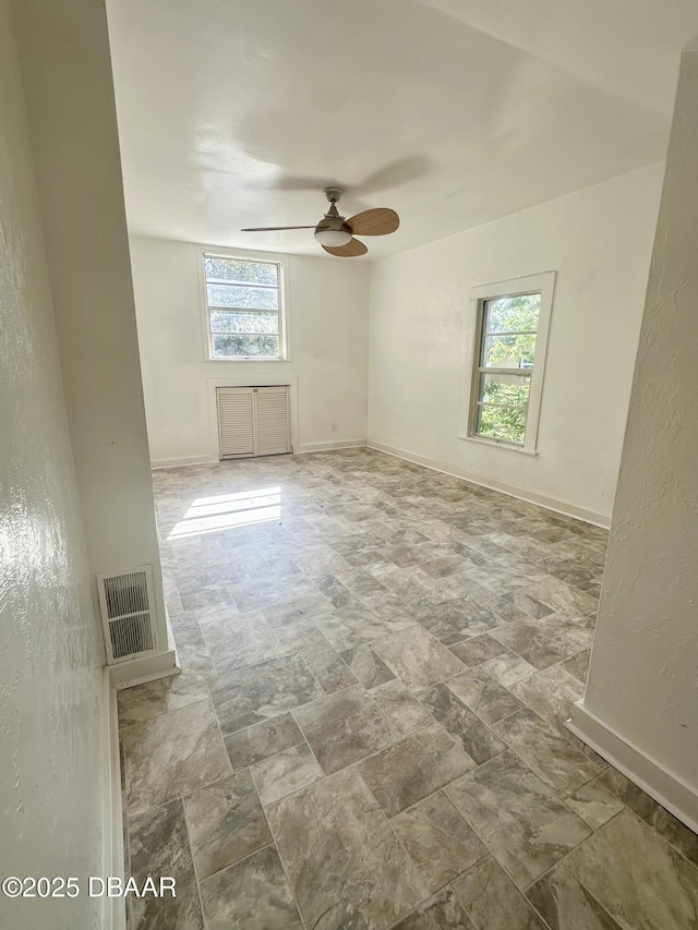 1011 S Peninsula Dr, Daytona Beach, FL 32118 - spare room featuring stone finish floors, a ceiling fan, and baseboards