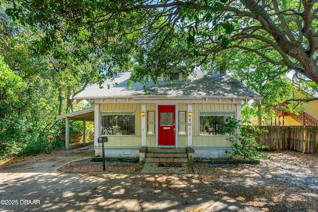 1011 S Peninsula Dr, Daytona Beach, FL 32118 - bungalow-style home with a shingled roof, board and batten siding, concrete driveway, entry steps, and a carport