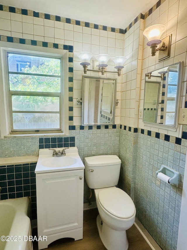 1011 S Peninsula Dr, Daytona Beach, FL 32118 - full bath featuring tile walls, plenty of natural light, toilet, a sink, and a bathtub