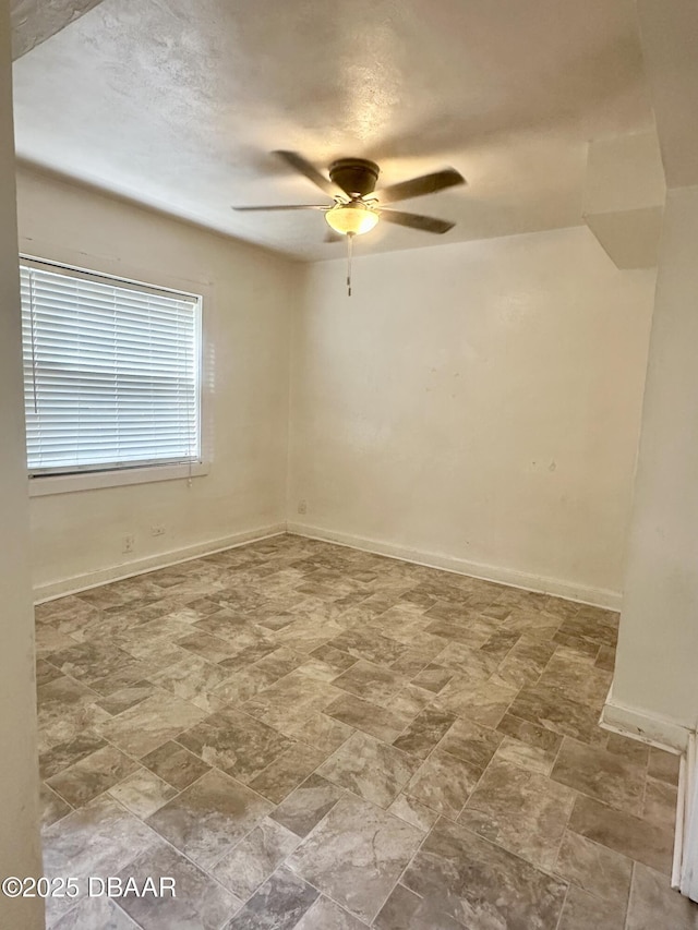 1011 S Peninsula Dr, Daytona Beach, FL 32118 - unfurnished room featuring ceiling fan, stone finish flooring, and baseboards