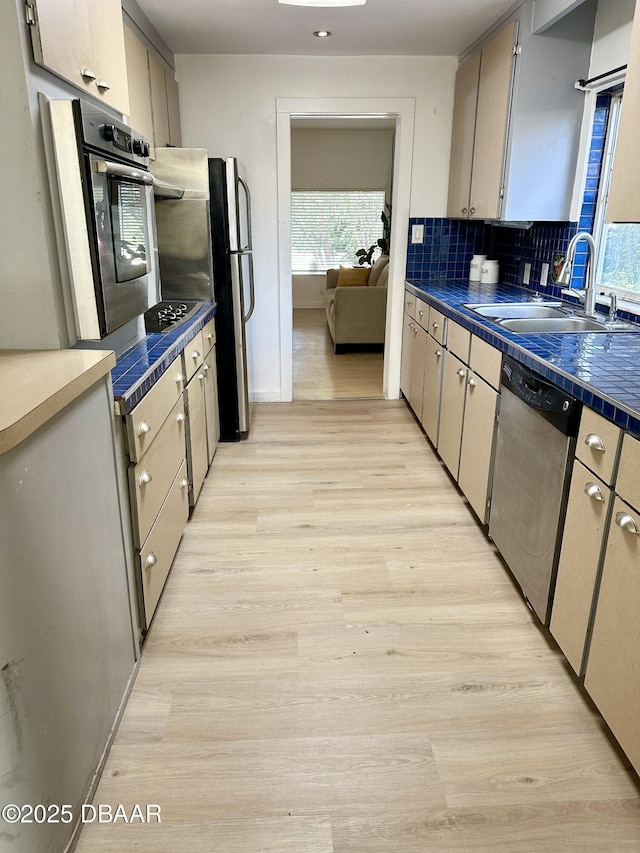 1011 S Peninsula Dr, Daytona Beach, FL 32118 - kitchen featuring stainless steel appliances, a sink, dark countertops, light wood finished floors, and healthy amount of natural light