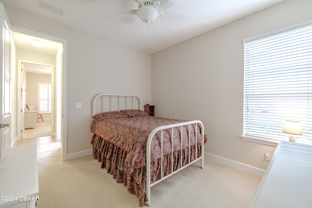 carpeted bedroom with multiple windows and ceiling fan