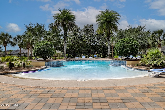 view of swimming pool with a patio and pool water feature