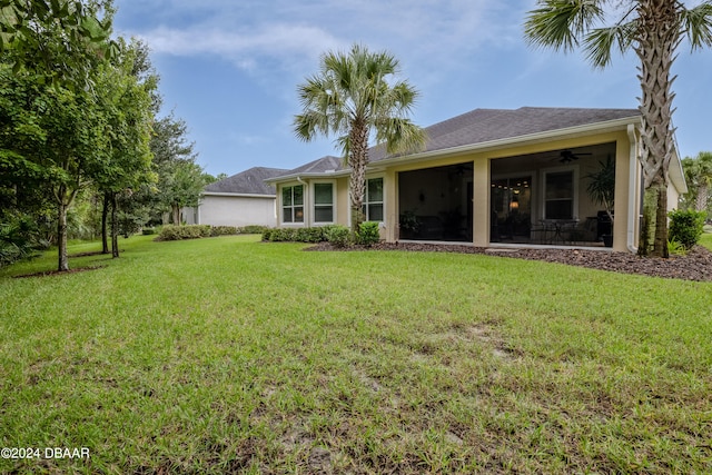 back of property featuring a lawn and ceiling fan