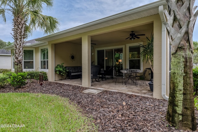 back of property featuring ceiling fan and a patio