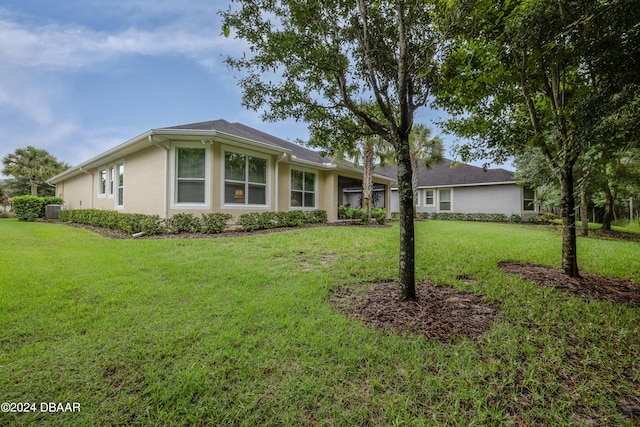 single story home with central air condition unit and a front yard