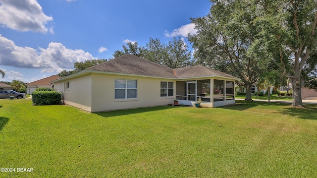 back of property with a lawn and a sunroom