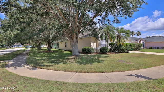 view of property hidden behind natural elements with a front yard