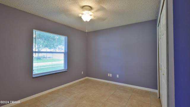 tiled spare room featuring a textured ceiling