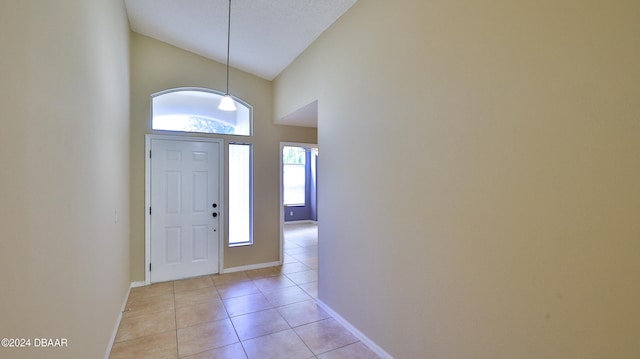 entrance foyer featuring high vaulted ceiling and light tile patterned floors