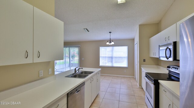 kitchen featuring stainless steel appliances, white cabinetry, hanging light fixtures, an inviting chandelier, and sink