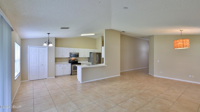 kitchen with white cabinets, appliances with stainless steel finishes, hanging light fixtures, and lofted ceiling