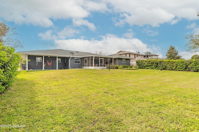 back of property with a sunroom and a yard