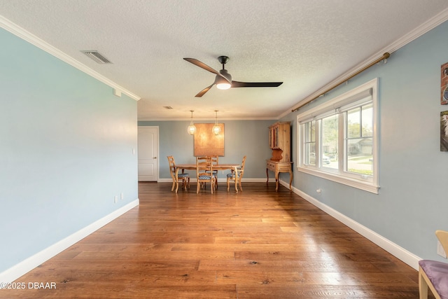 dining space with baseboards, ornamental molding, visible vents, and wood finished floors