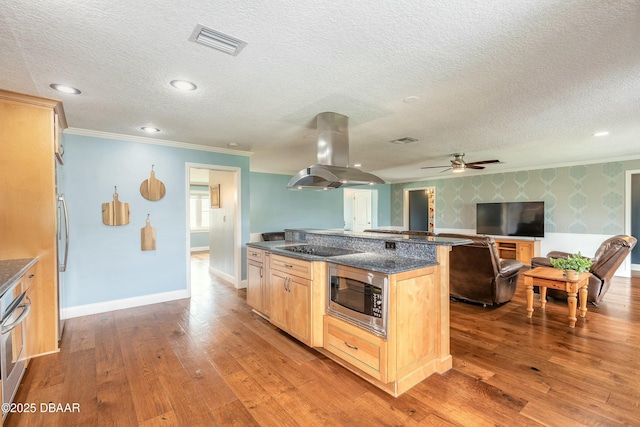 kitchen featuring open floor plan, visible vents, island range hood, wallpapered walls, and stainless steel appliances