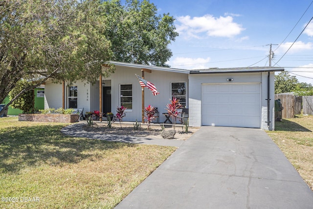 ranch-style house featuring concrete block siding, fence, a garage, a front yard, and aphalt driveway