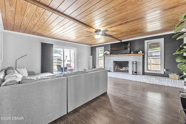 living area featuring wood ceiling, ornamental molding, a brick fireplace, and plenty of natural light