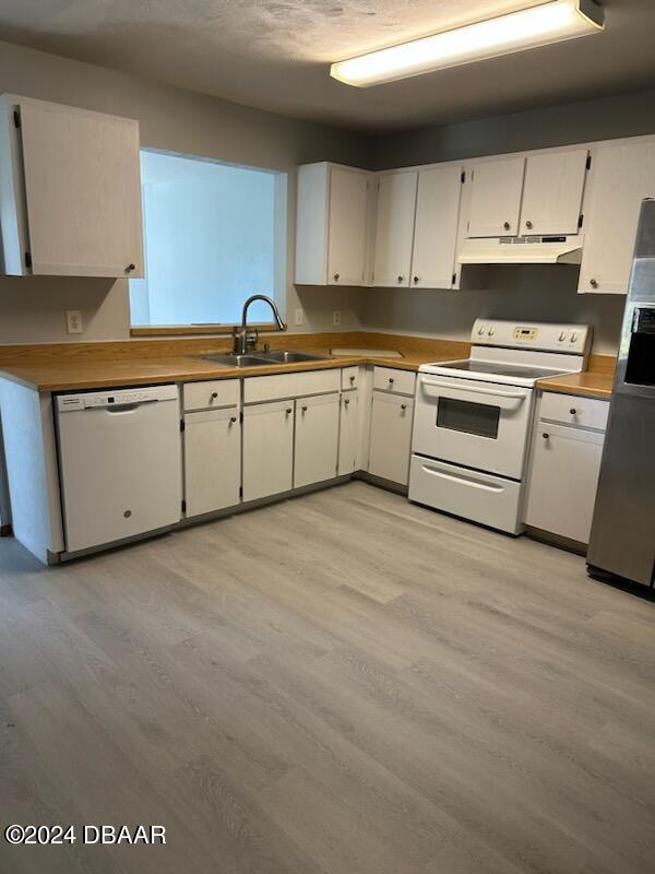 kitchen with white cabinets, white appliances, sink, and light wood-type flooring