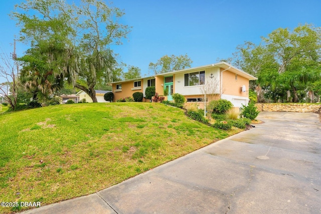 21 Pine Valley Cir, Ormond Beach, FL 32174 - raised ranch with driveway, an attached garage, stucco siding, and a front lawn