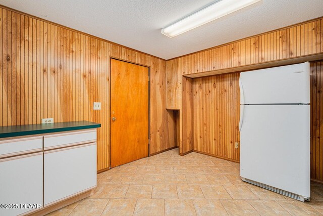 21 Pine Valley Cir, Ormond Beach, FL 32174 - kitchen with freestanding refrigerator, wood walls, a textured ceiling, and dark countertops
