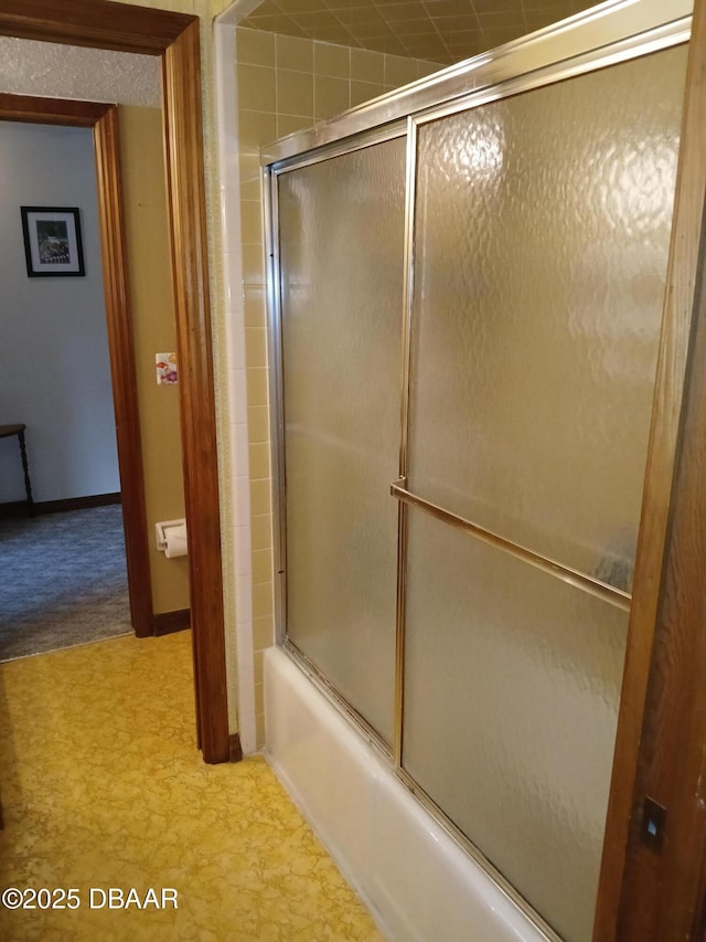 bathroom featuring combined bath / shower with glass door