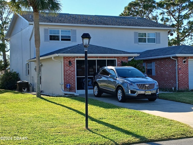 front of property with a garage, a front lawn, and central AC unit