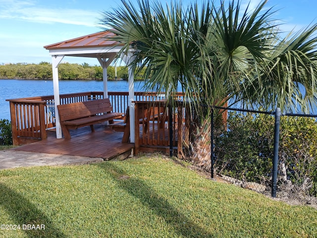 dock area with a deck with water view, a gazebo, and a yard