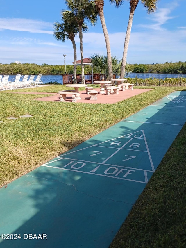 view of property's community with a water view and a yard