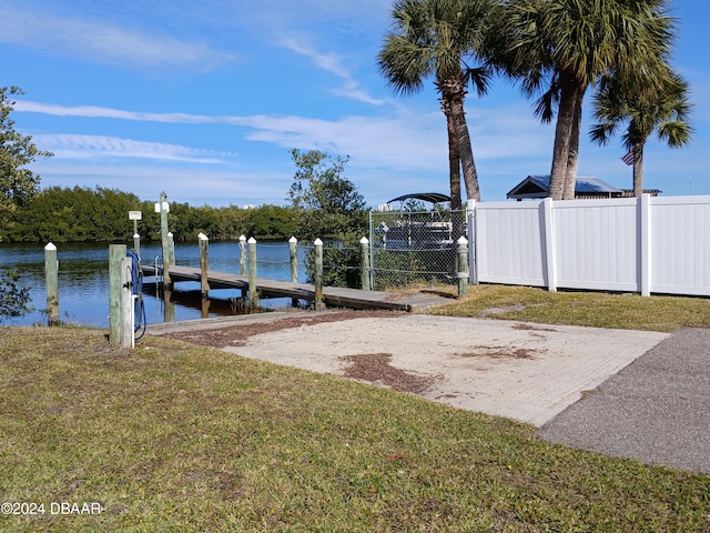 view of dock with a water view and a lawn