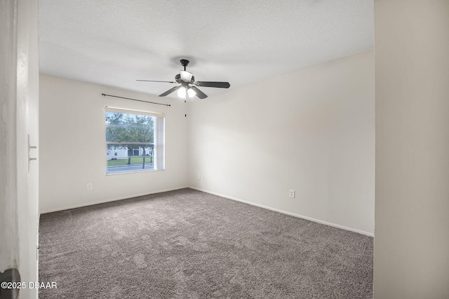 carpeted spare room featuring a ceiling fan, a textured ceiling, and baseboards