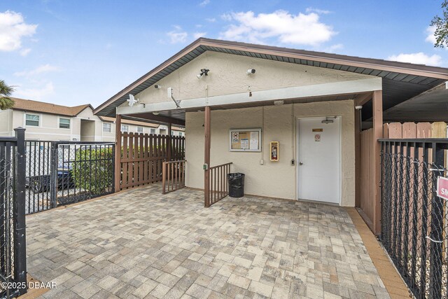 back of house with fence, a patio, and stucco siding