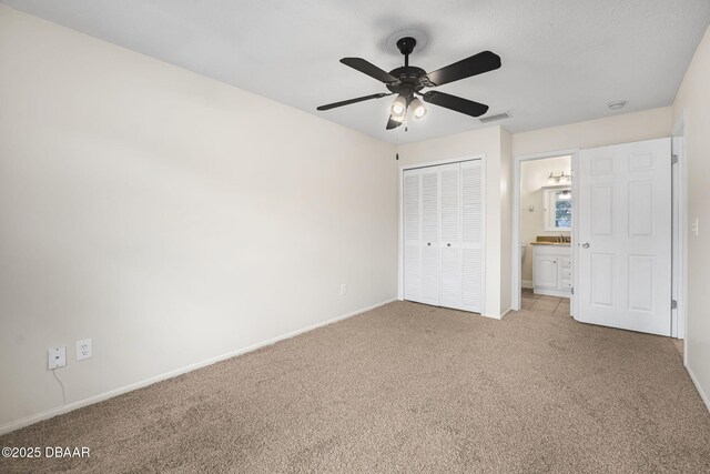 unfurnished bedroom featuring baseboards, visible vents, ceiling fan, carpet, and a closet