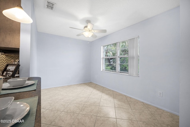 spare room with visible vents, ceiling fan, baseboards, and light tile patterned floors