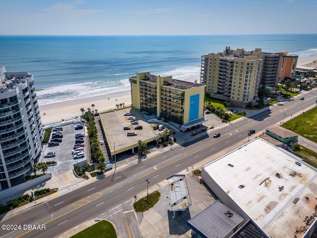 birds eye view of property with a water view and a beach view